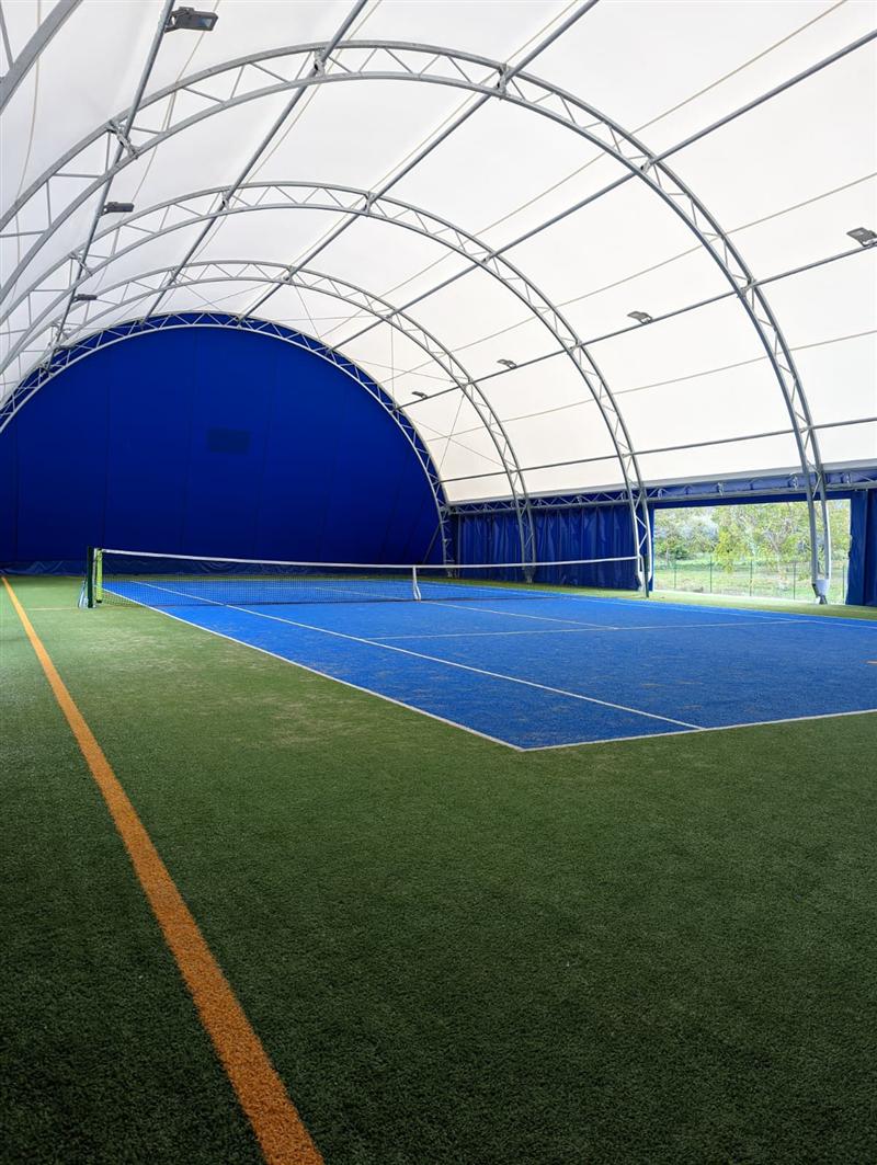 Il campo da tennis coperto di ASD Blue Sport Academy Vasto, con fondo blu e bordi in erba sintetica