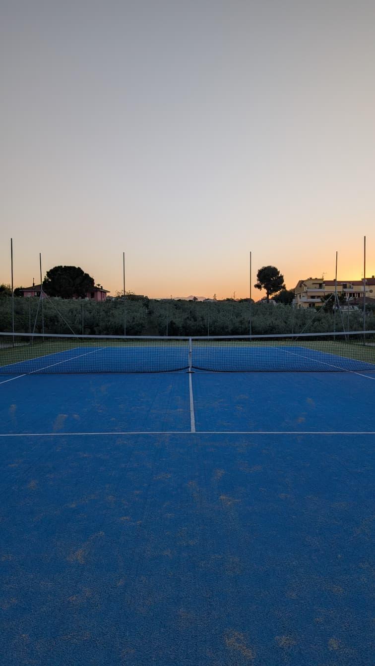 Campo da tennis blu al tramonto